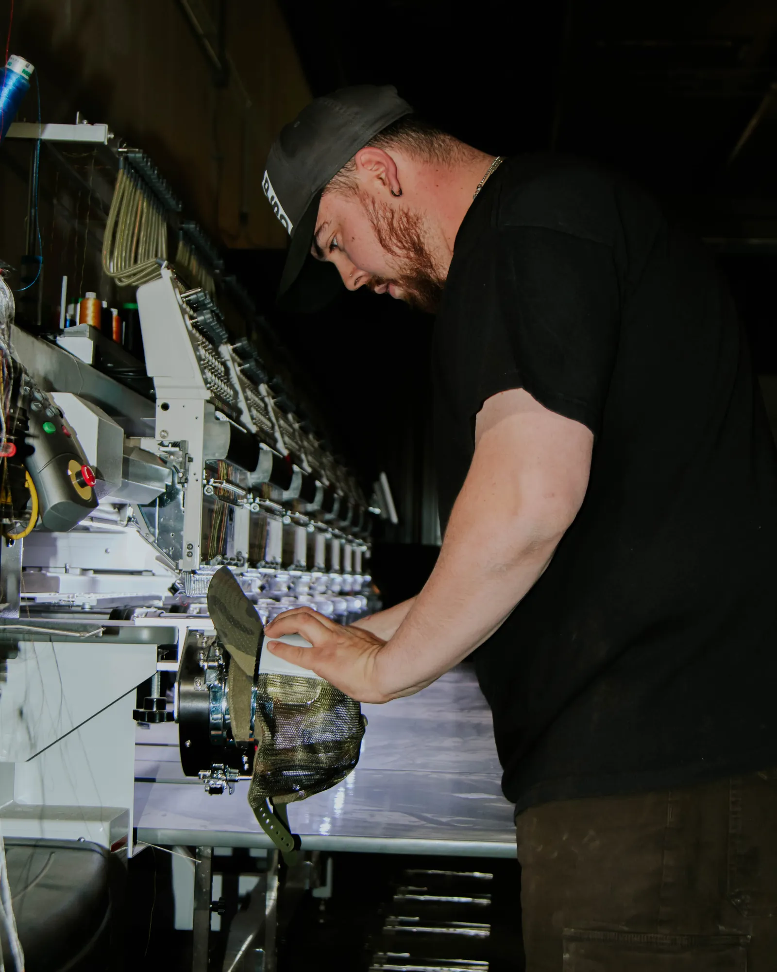 Operator running a multi-head embroidery machine at Fully Exposed Graphics, a women-owned print shop in Albuquerque