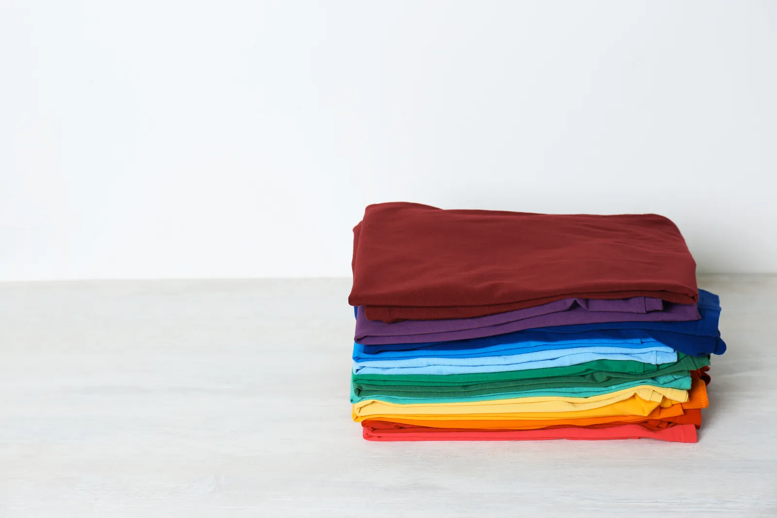 Stack of folded custom printed t-shirts in multiple colors