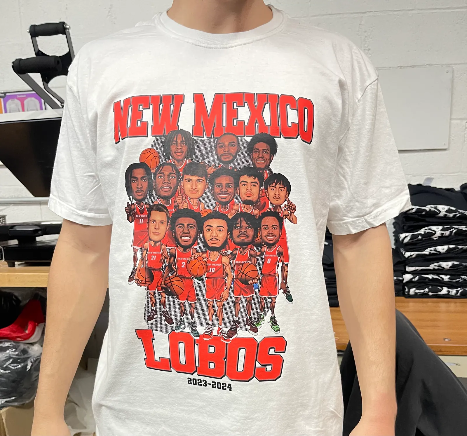 Customer wearing a white New Mexico Lobos caricature t-shirt custom screen printed at Fully Exposed Graphics